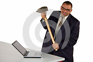 Angry businessman hitting laptop with sledgehammer