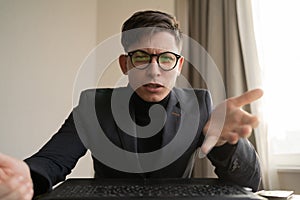 Angry businessman making video call on laptop in office, webcam view, manager communicating with client in zoom