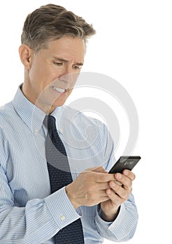 Angry Businessman Messaging Through Mobile Phone