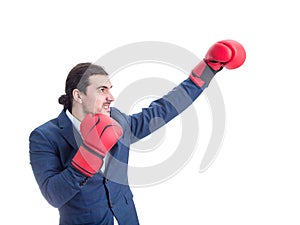 Angry businessman with red boxing gloves, punching with hand, fighting position, clenching teeth. Side view portrait of determined