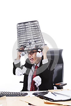 Angry businessman with rubbish bin on his head