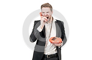 Angry businessman shout in vintage phone receiver holding landline telephone, telephony