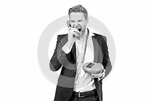 Angry businessman shout in vintage phone receiver holding landline telephone, telephony