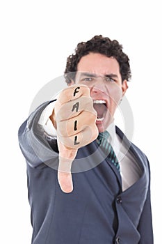 Angry businessman showing thumb down gesture as rejection symbol