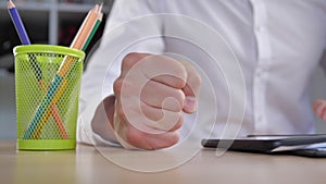 Angry Businessman with a smartphone in his hands hits the table with his fist. Stress at work