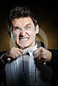 Angry businessman tearing document