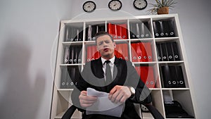 Angry businessman tearing up a document, contract or agreement