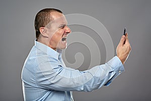 Angry businessman yelling at cellphone