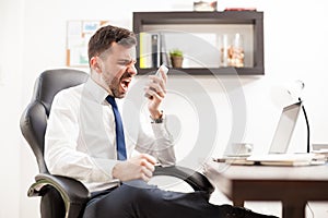 Angry businessman yelling at the phone