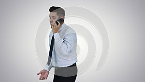 Angry businessman yelling at phone on gradient background.