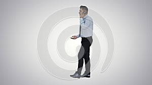 Angry businessman yelling at phone on gradient background.