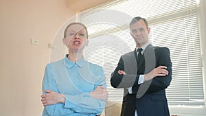 Angry businessmen, man and woman in the office, screaming at the camera close-up