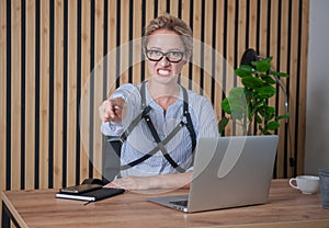 Angry businesswoman pointing out in the office