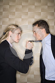 Angry Businesswoman Pulling Man's Tie