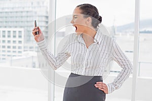 Angry businesswoman screaming at her phone