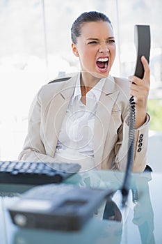 Angry businesswoman screaming at her phone