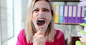 Angry businesswoman screaming with magnifying glass in front of mouth near lot of documents 4k movie slow motion