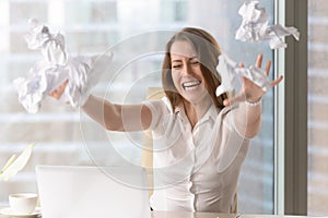 Angry businesswoman throwing crumbled papers