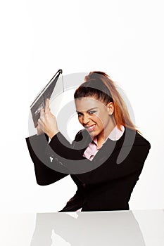 Angry businesswoman about to smash her laptop