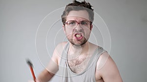 Angry caucasian man with glasses threating his neigbour with a hammer.