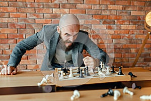 Angry chess player beats his fist on the board