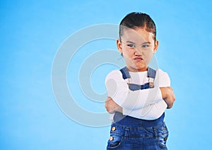 Angry, child and arms crossed with tantrum in studio with mockup space. Kid, young girl and frustrated with cross frown