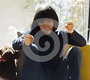 Angry child banging fists with violence fed up of isolation