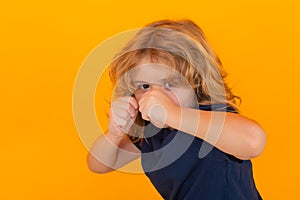 Angry child with fist gesture fight, hit on studio isolated background. Boy fight, battle. Kid boy with mad expression