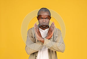 Angry confident sad middle aged african american man in casual crossed arms, doing stop sign