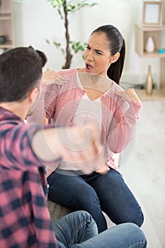 angry couple fighting sitting on couch at home