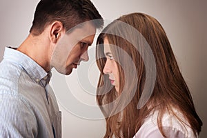 Angry couple looking at each other close