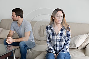 Angry couple sitting separately on couch ignoring each other photo