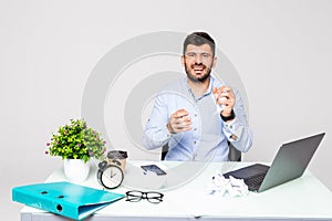 Angry crazy businessman in glasses with beard yelling and crumpling paper on his workplace