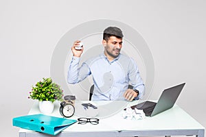 Angry crazy businessman in glasses with beard yelling and crumpling paper on his workplace