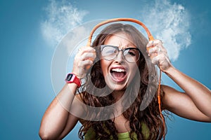 Angry crazy girl in headphones listening to music.