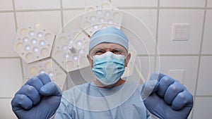 Angry doctor in rubber glove stands over patient in operating room