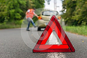 Angry driver kicking the tires on broken car