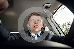 Angry driver shouting sitting behind the wheel of of the car