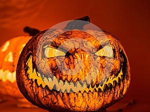 The angry face with the sharp teeth of the orange scary pumpkin