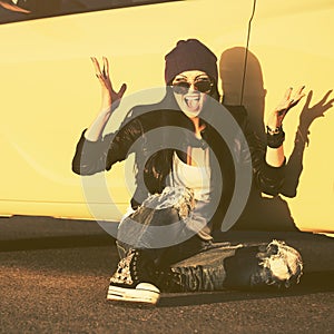 Angry fashion hipster woman sitting on sidewalk next to her car