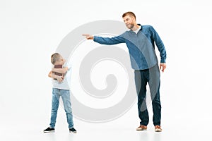 Angry father scolding his son in living room at home