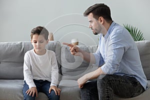 Angry father scolding sad kid son for bad behavior