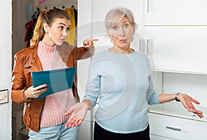 Angry female householder demanding older woman to pay off debt