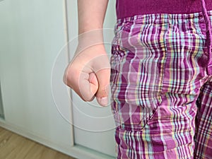 Angry fist of a child near leg. Children negative emotions and anger