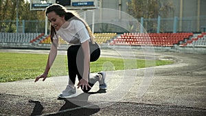 Angry fit asian runner in sportswear prepares to run. sprinting on stadium track