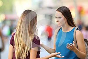 Angry friends having a serious conversation outdoors