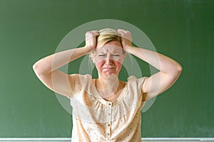 Angry frustrated school teacher tearing at hair