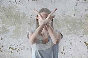 Angry and frustrated woman shows her crossed arms in x gesture sign