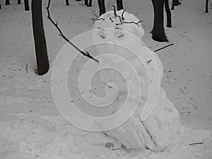 Angry funny snow man on winter day in the forest