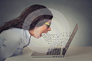 Angry furious businesswoman working on computer, screaming